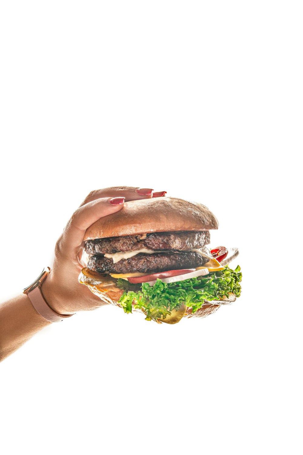 a person holding a hamburger in their hand
