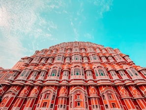 The majestic facade of a royal palace with detailed arches and ornate balconies under a clear blue sky.