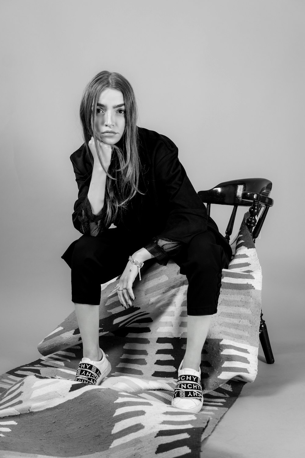 a black and white photo of a woman sitting on a chair