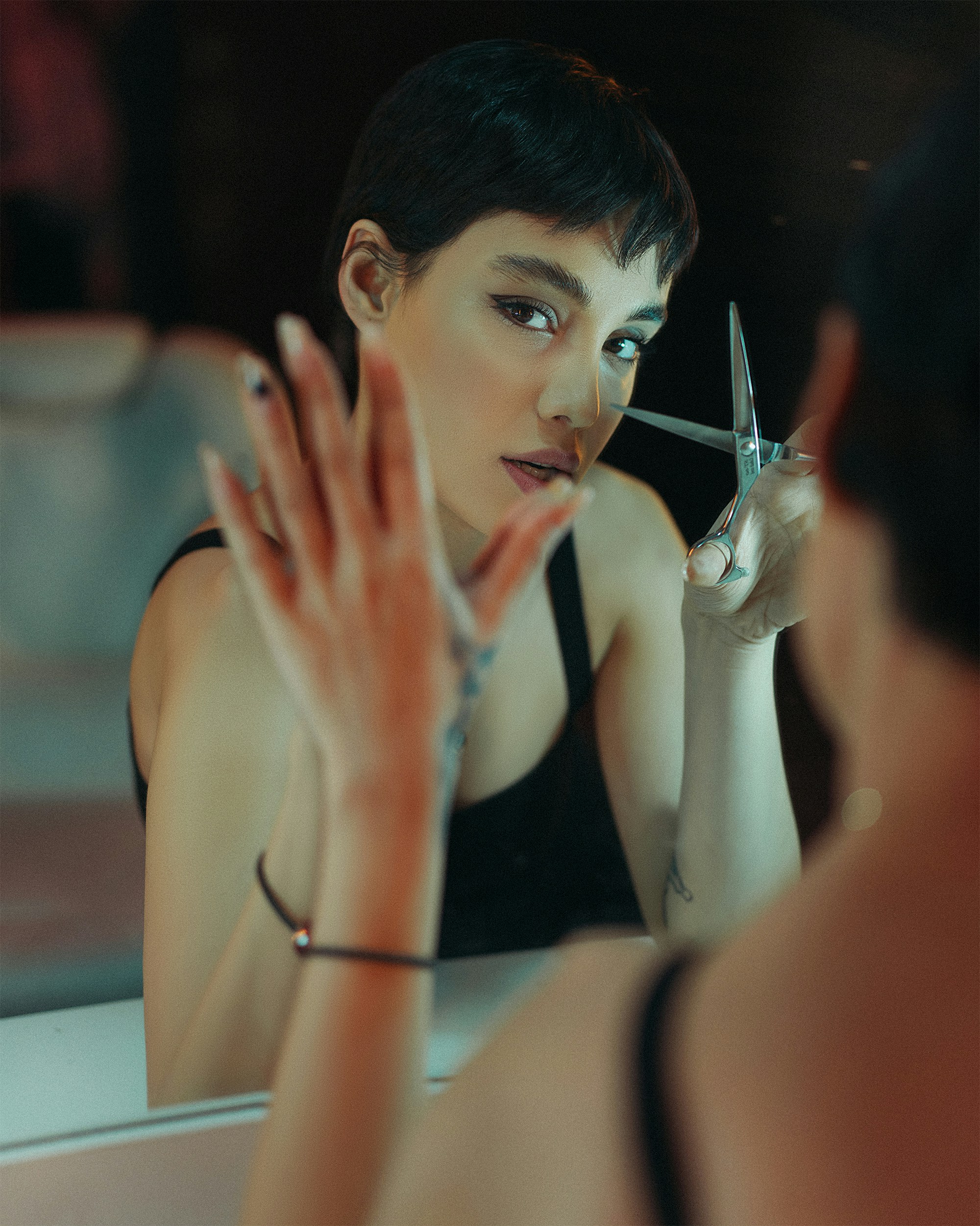 a woman holding a pair of scissors in front of her face