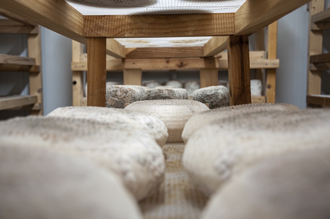 a pair of shoes sitting on top of a wooden bench, Cheese production.
