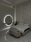 a bedroom with a marble wall and a round mirror