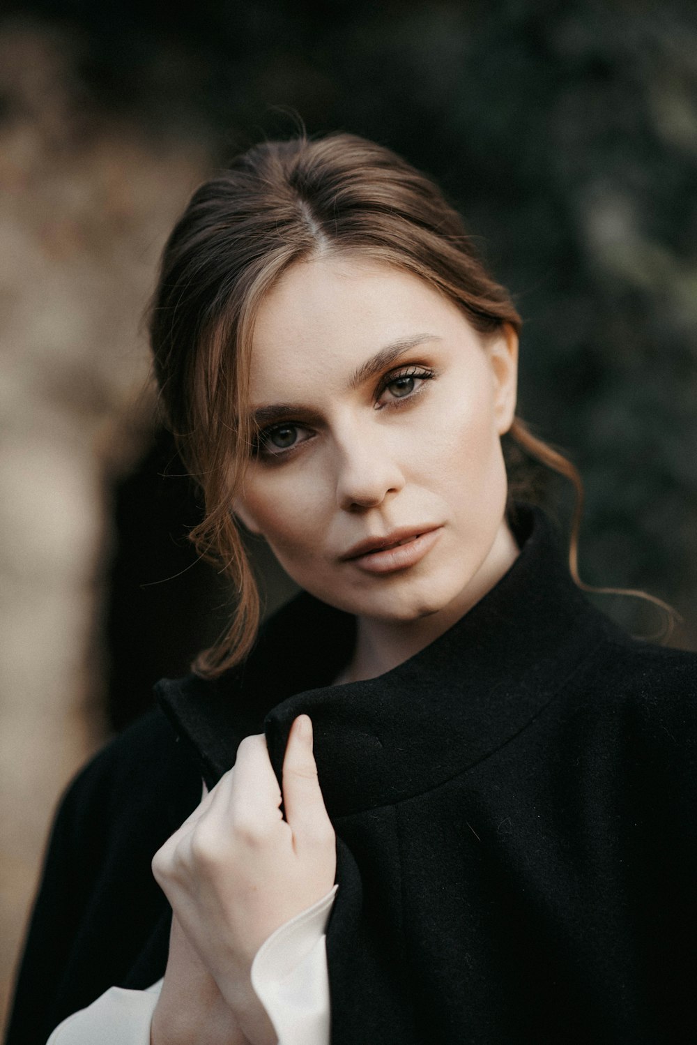 a woman in a black coat posing for a picture