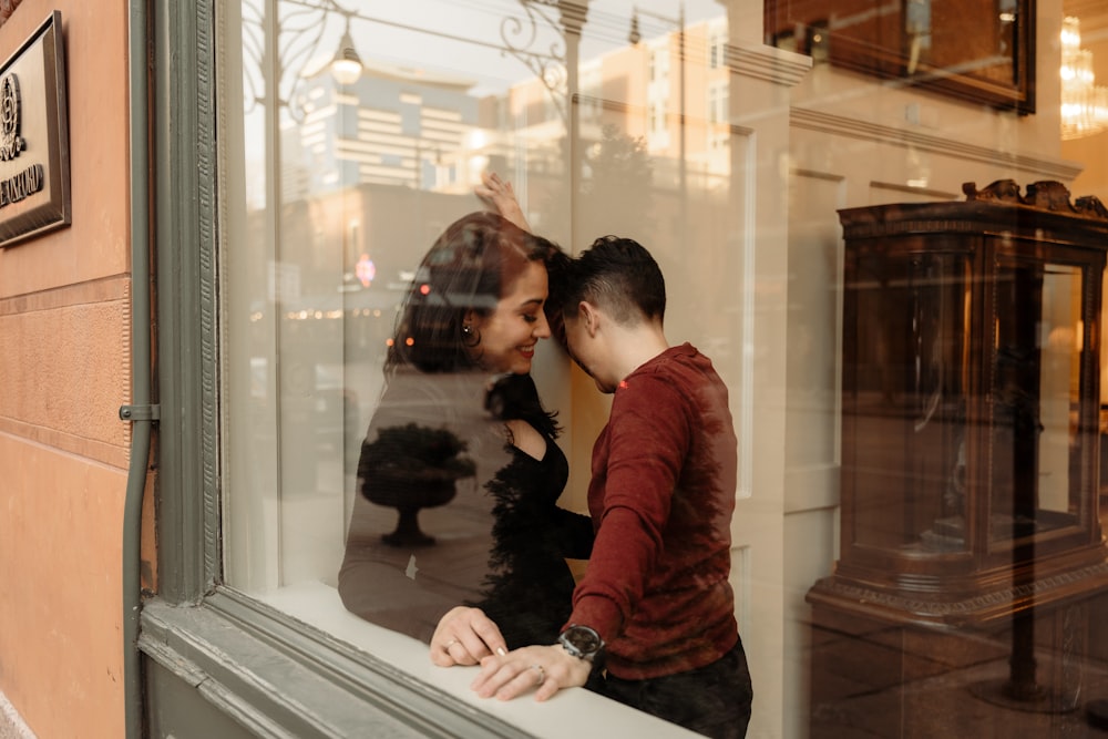 a man and a woman looking out a window