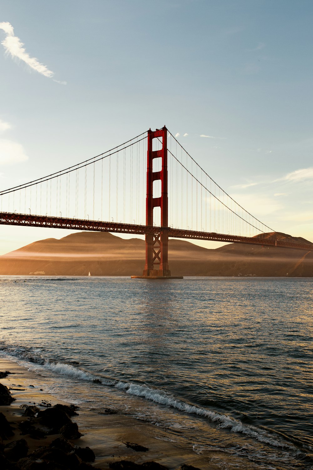 the golden gate bridge over the water at sunset