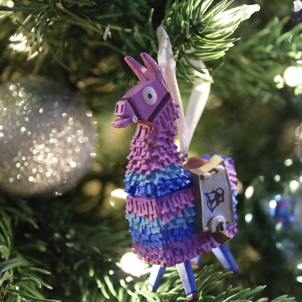 Ein buntes Lama-Ornament, das an einem Weihnachtsbaum hängt