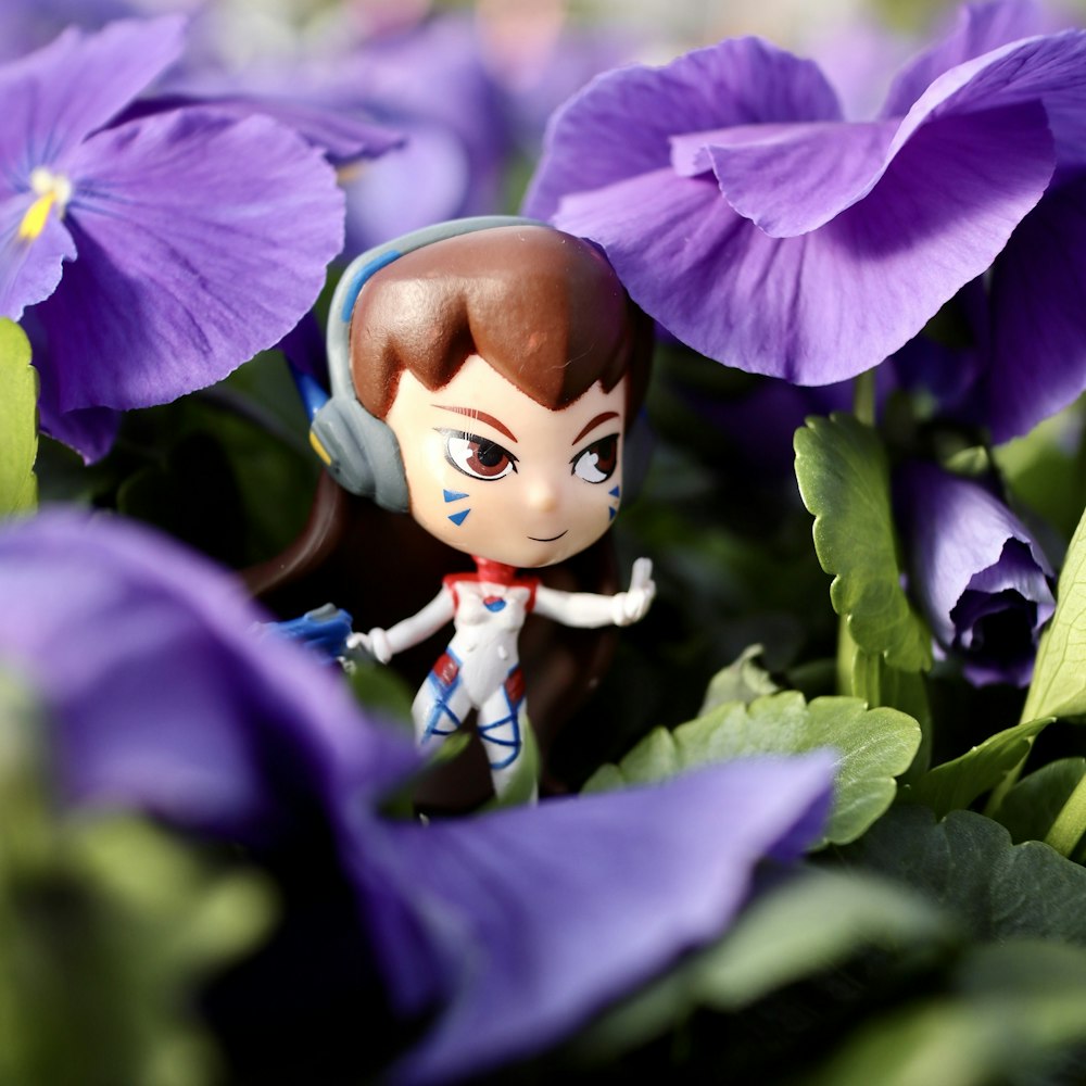 a figurine of a girl in a field of purple flowers