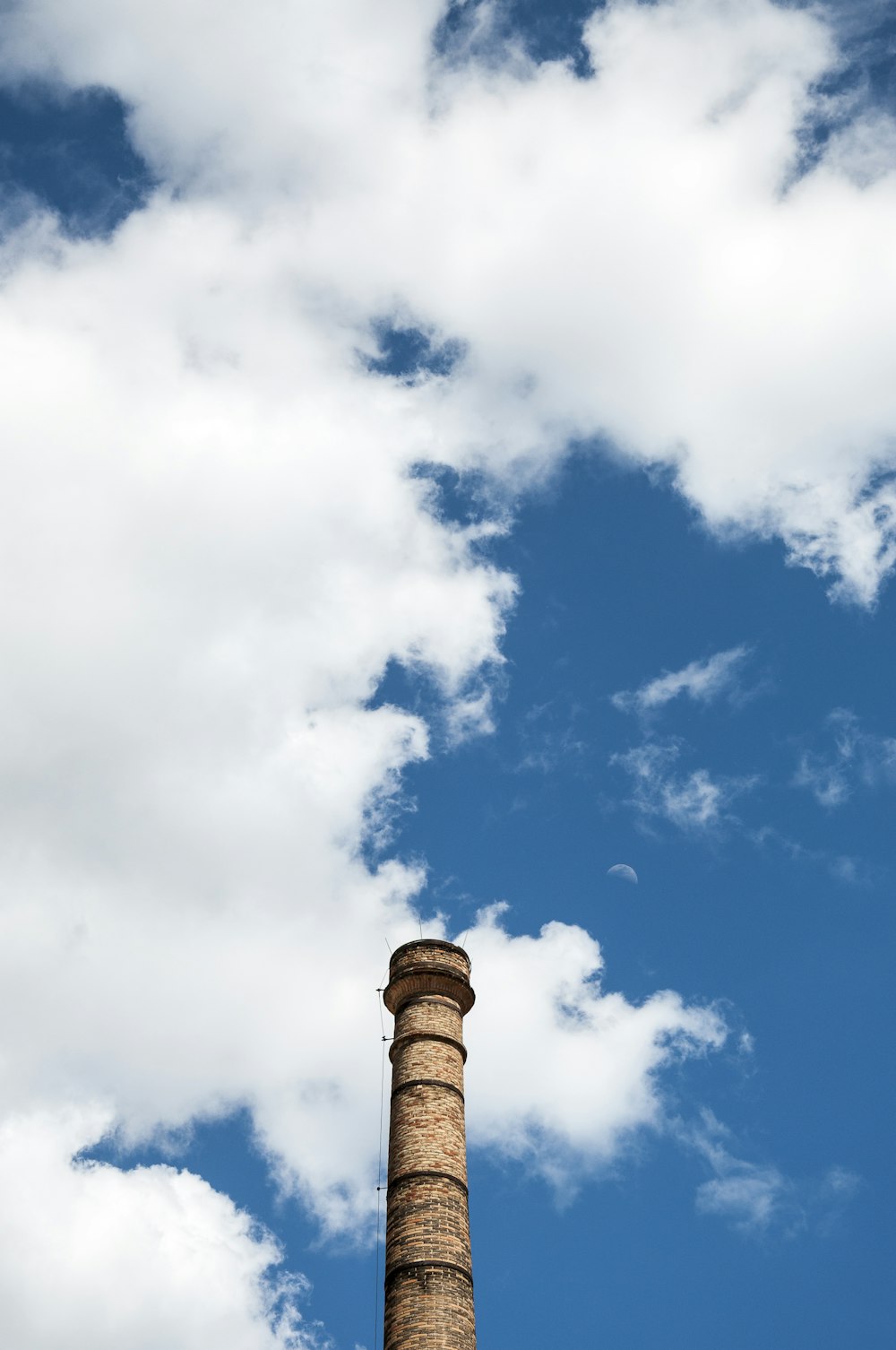 a tall brick chimney with a blue sky in the background