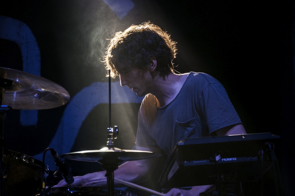 a man playing drums in front of a microphone