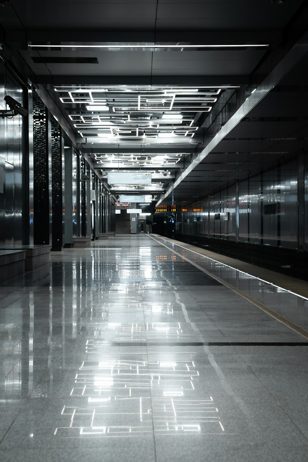 a long hallway in a building with lights on the ceiling