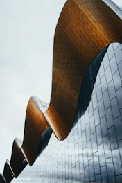 a tall building with a curved roof next to a traffic light