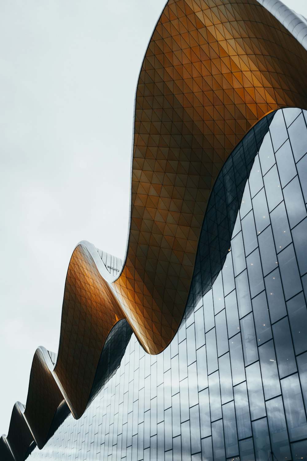 a tall building with a curved roof next to a traffic light