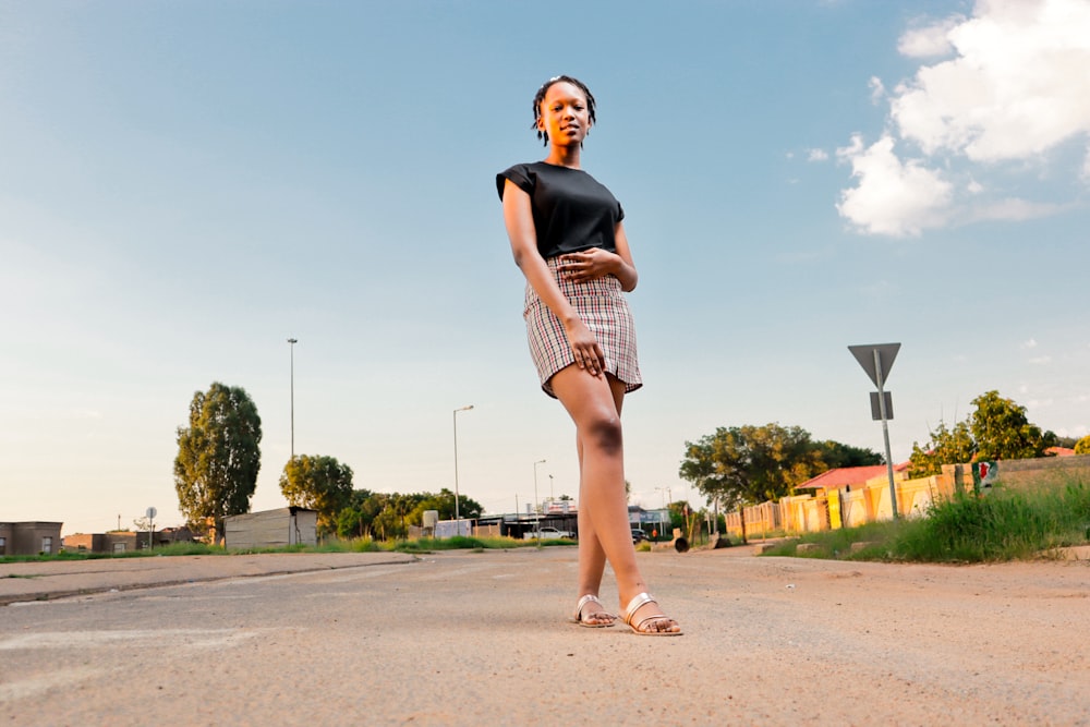 a woman standing in the middle of a road