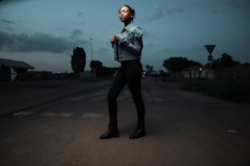 A uniformed security guard walking confidently on a residential street at dusk.