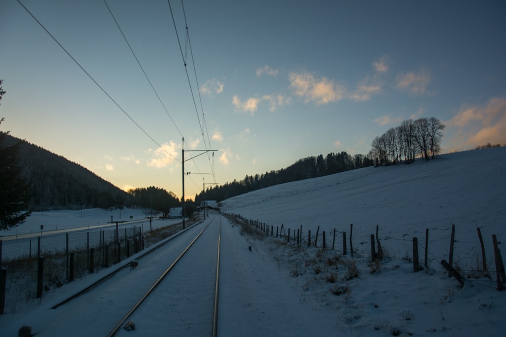 a train track running through a snow covered field