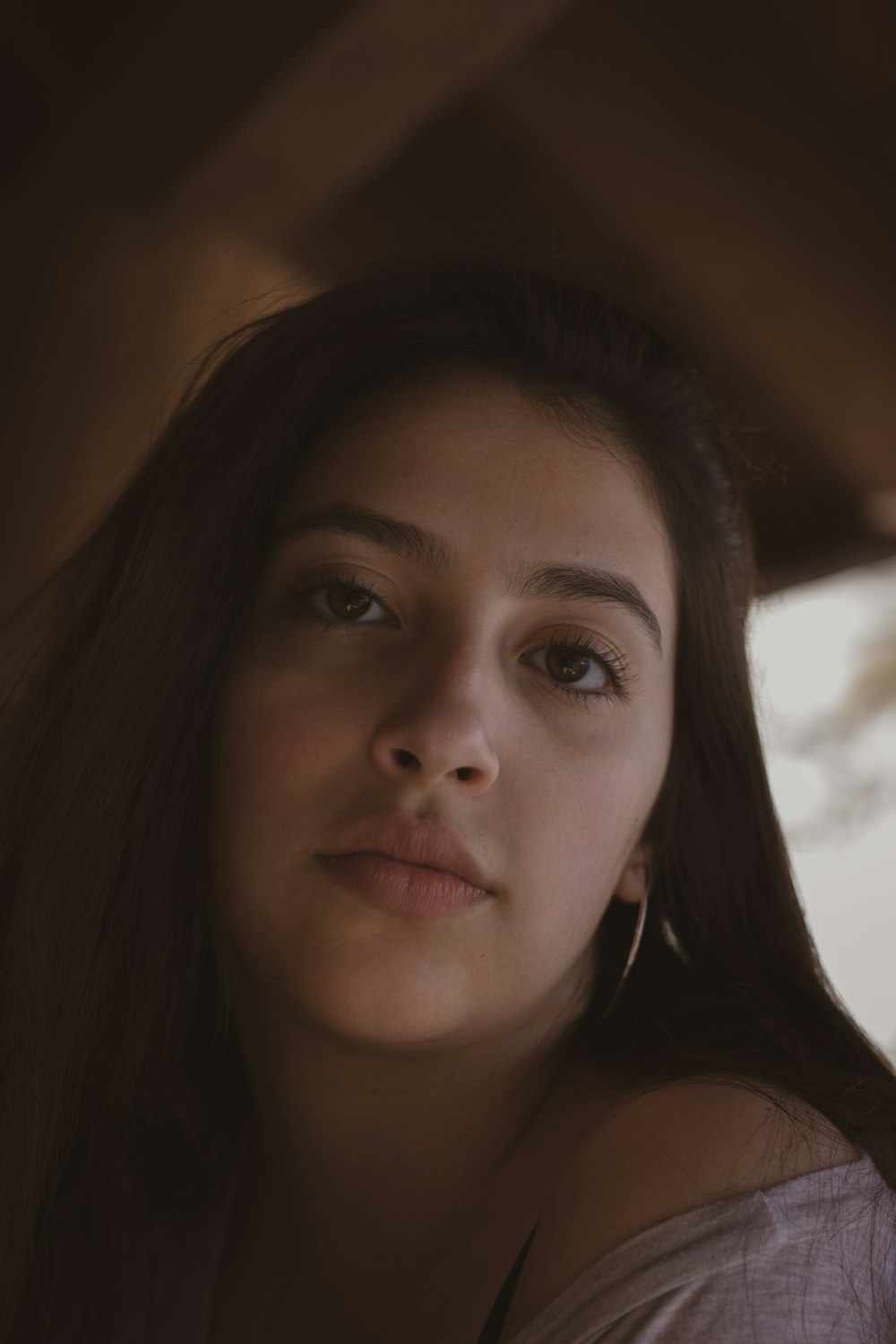 a woman with long brown hair is looking at the camera