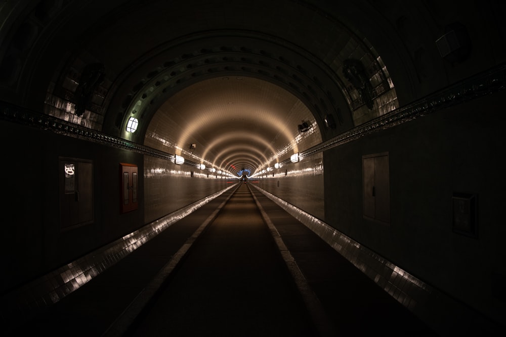 a dark tunnel with lights at the end of it