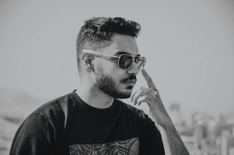 a man with a beard and sunglasses smoking a cigarette