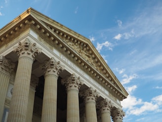 a tall building with columns and a sky background