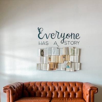 a brown leather couch sitting in front of a white wall