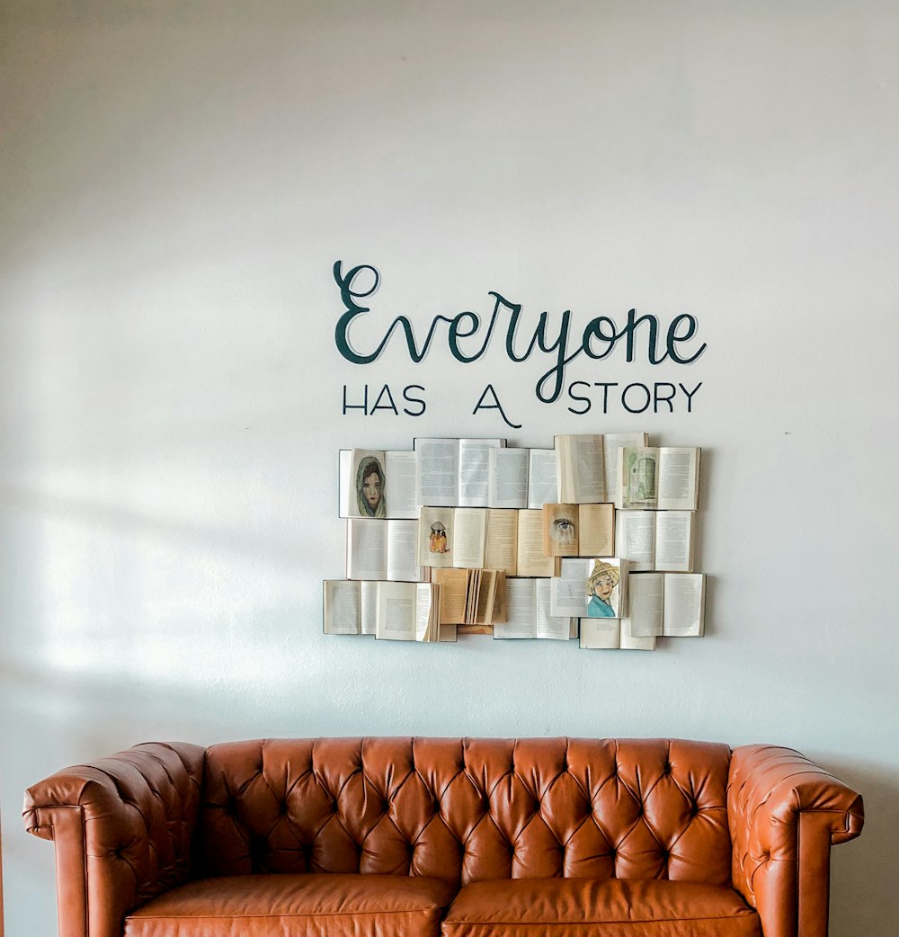 a brown leather couch sitting in front of a white wall