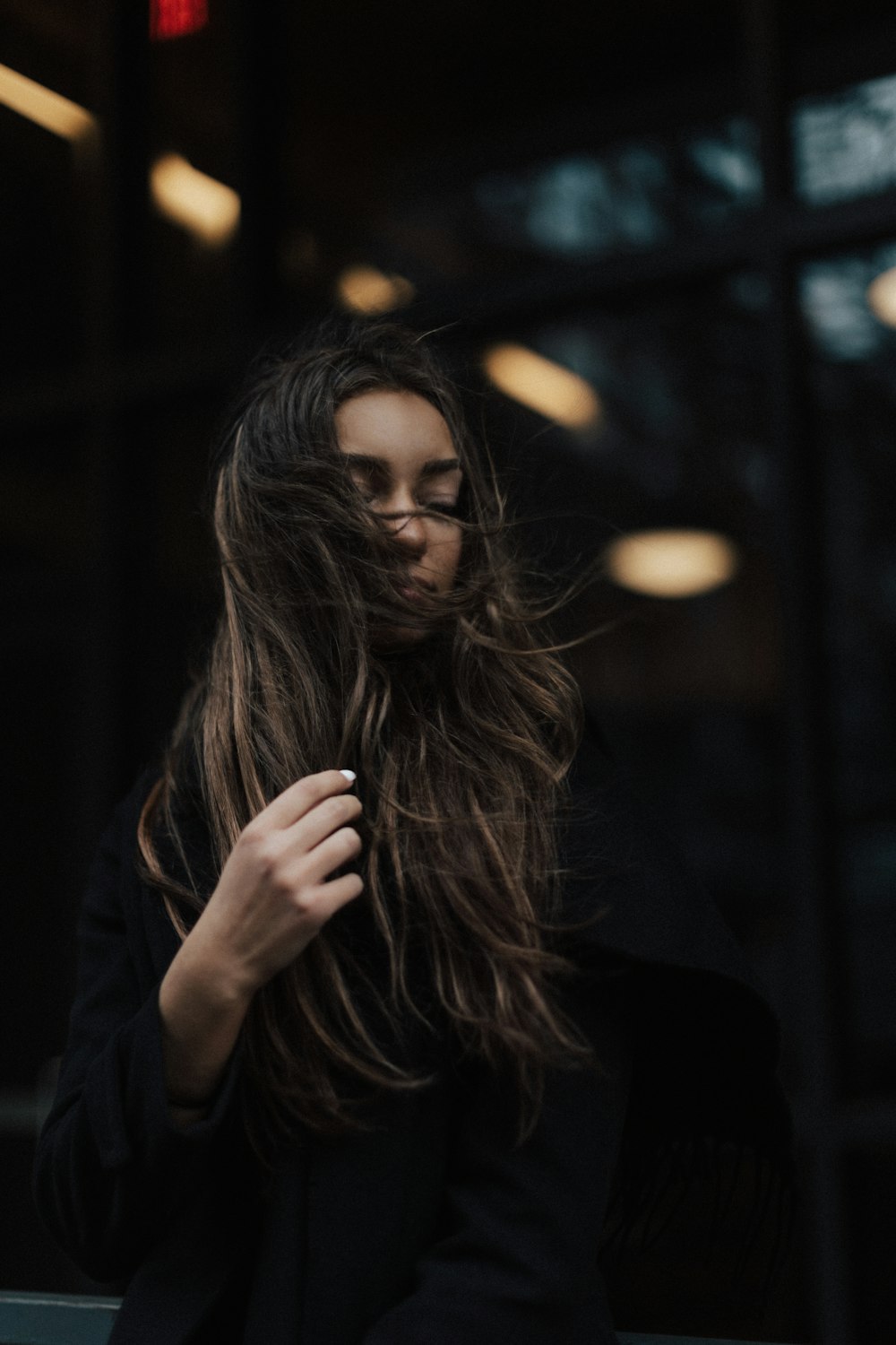 a woman with long hair standing in front of a building