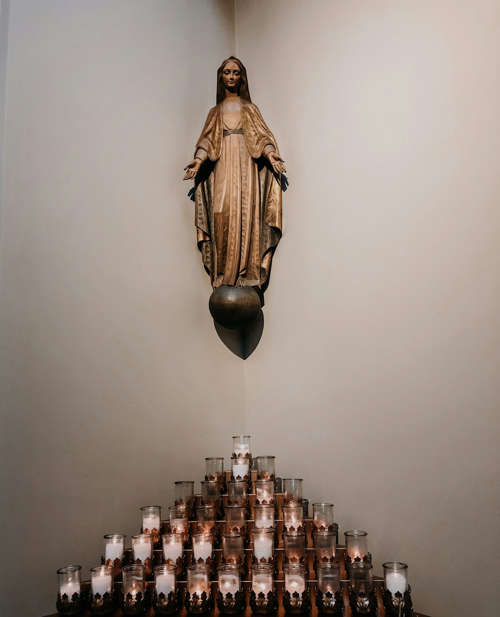 a statue of the virgin mary surrounded by candles