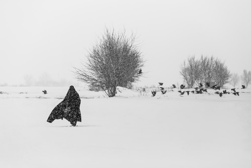 une personne marchant dans la neige avec un manteau