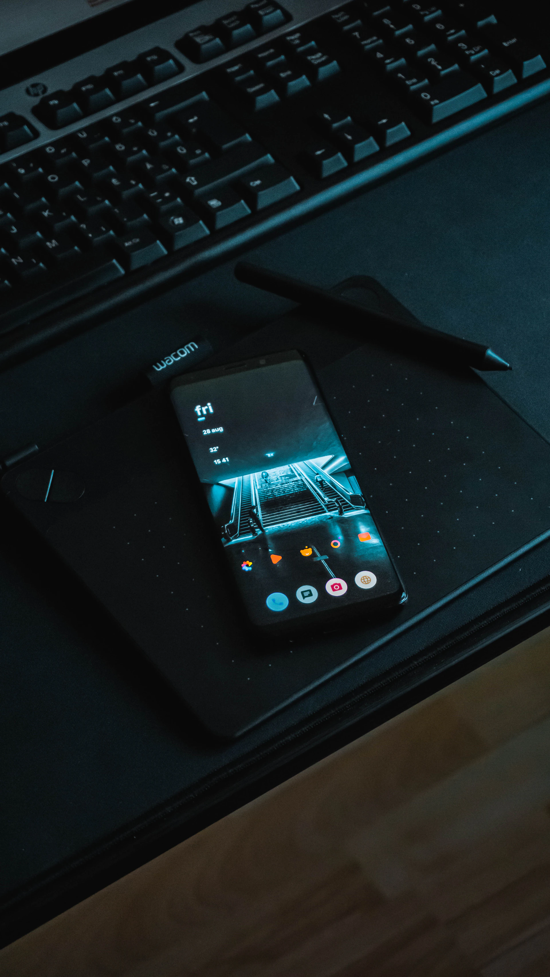 a cell phone sitting on top of a desk next to a keyboard