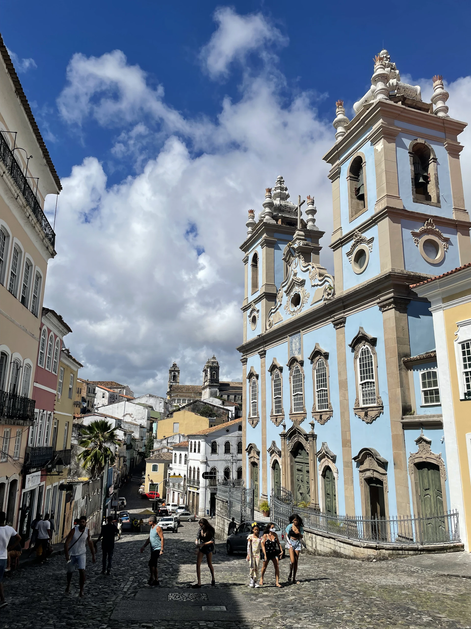 a group of people walking down a cobblestone street