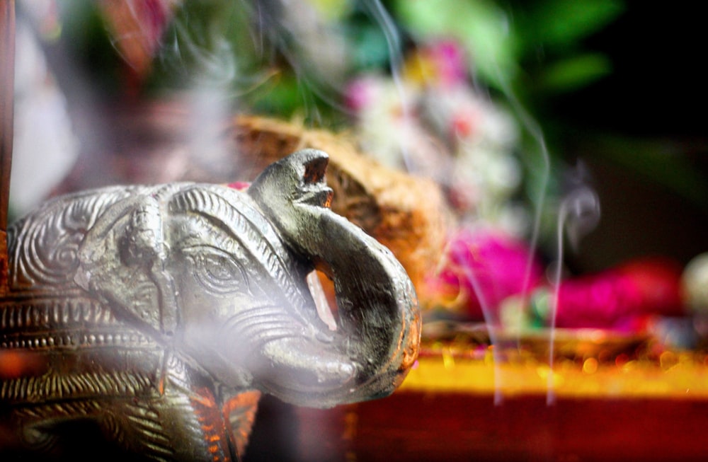 a silver elephant statue sitting on top of a wooden table