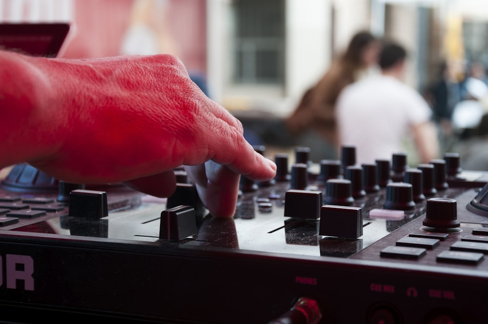 a hand is pressing buttons on a sound board