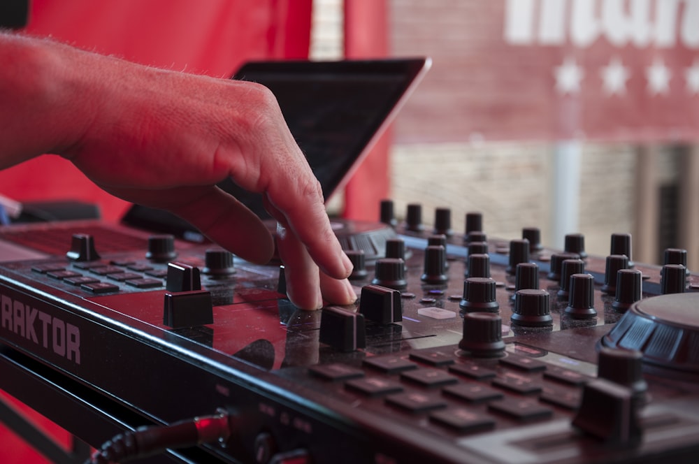 a hand is touching the knobs on a dj's mixer