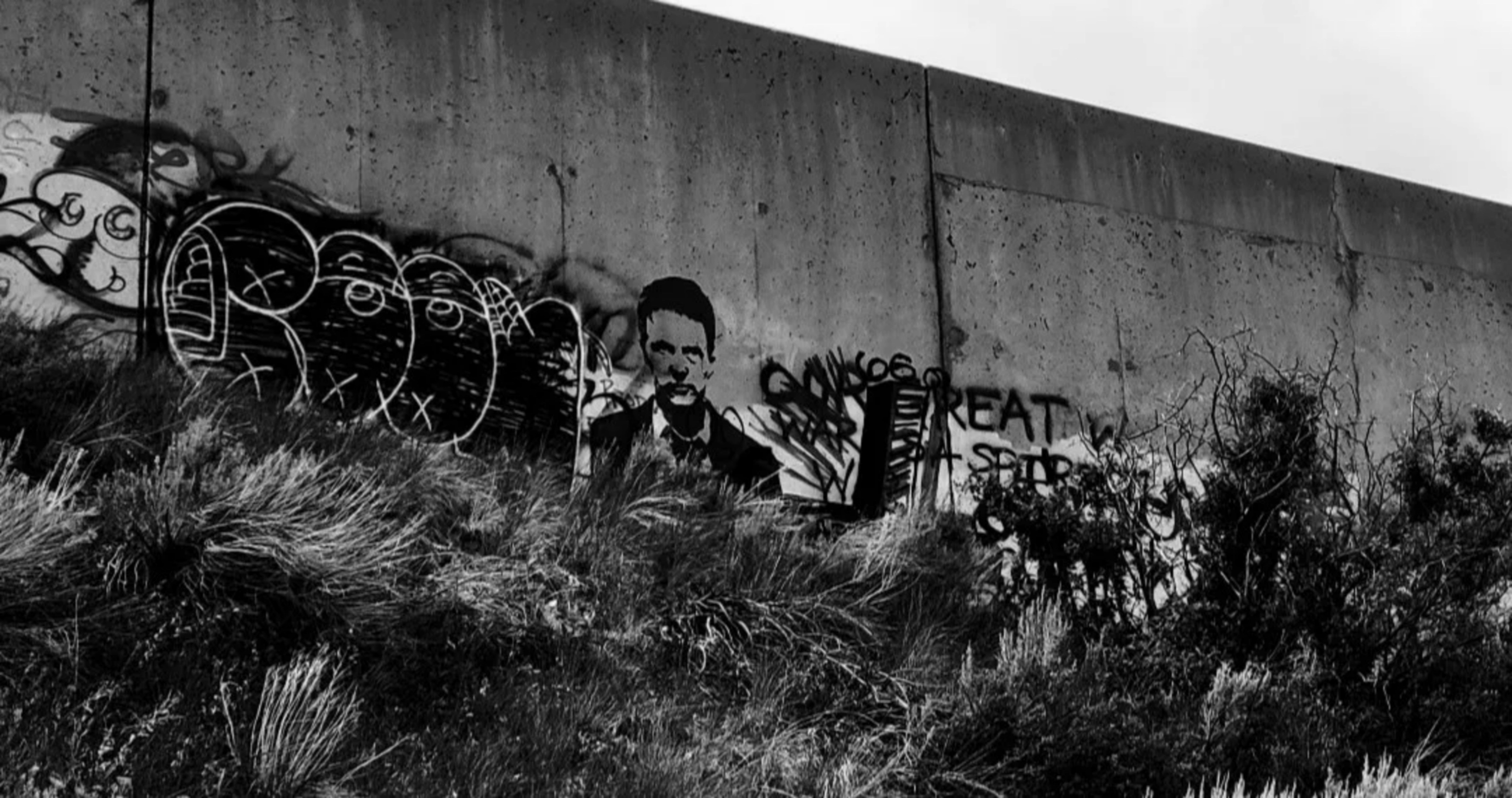 a black and white photo of graffiti on a wall