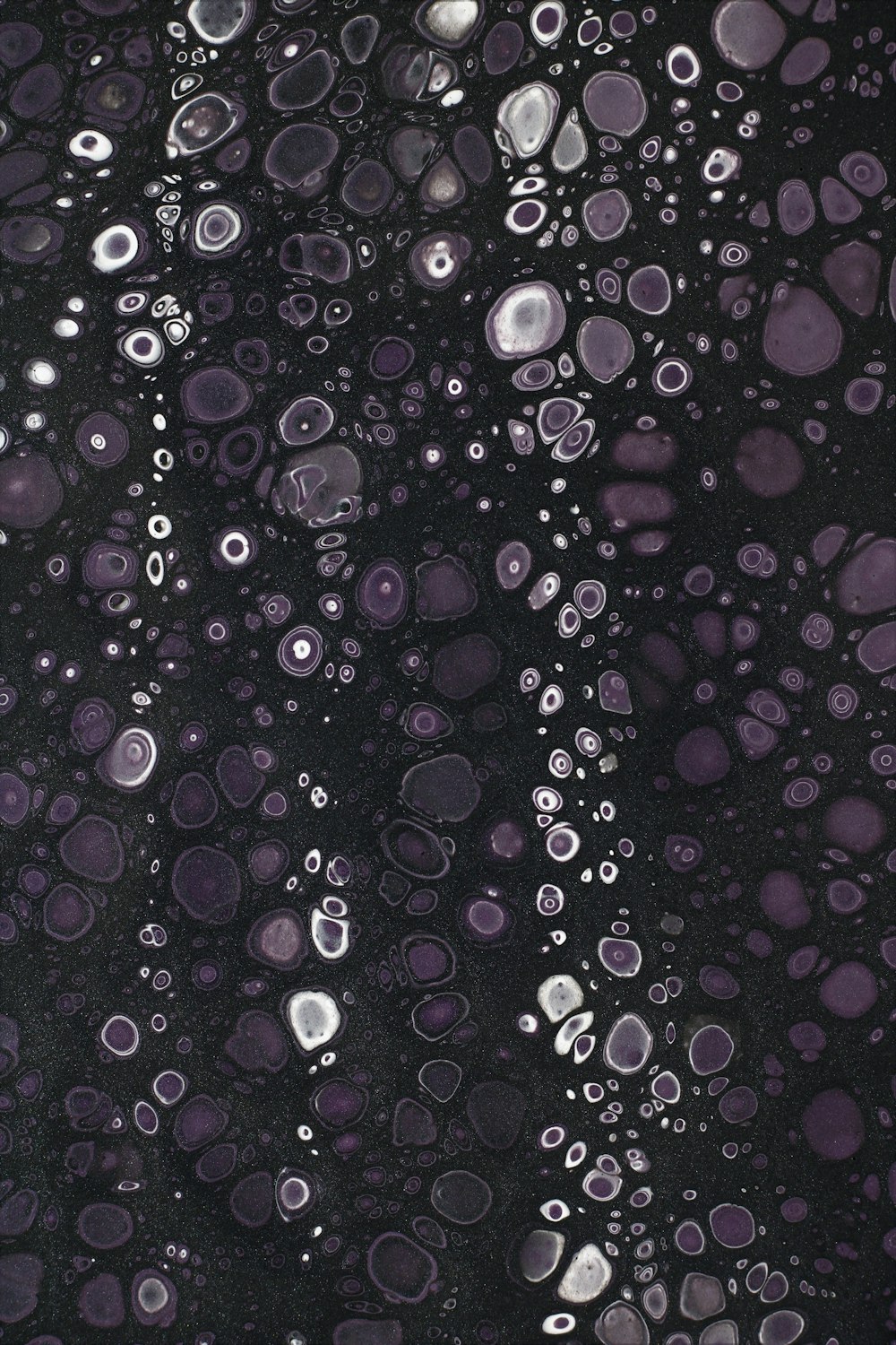 a close up of water bubbles on a black surface