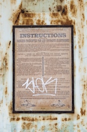 a rusted metal sign with writing on it