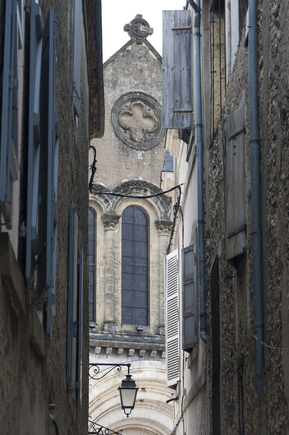 Un vicolo stretto con una torre dell'orologio sullo sfondo