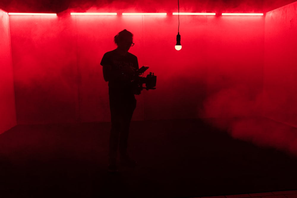 a person standing in a room with a red light