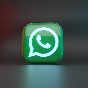 A glossy three-dimensional green cube displays the WhatsApp logo, which is illuminated with a bright white glow. The background is a soft gradient of dark colors, enhancing the focus on the logo.