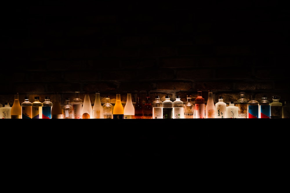 a group of bottles sitting next to each other in a dark room
