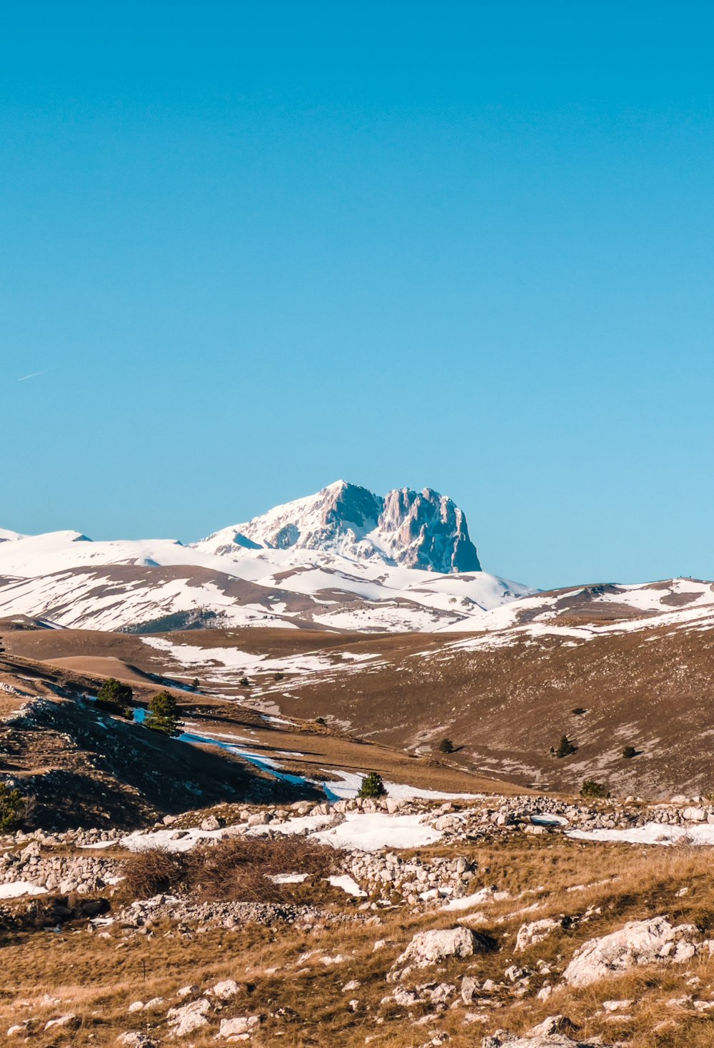 a mountain range with a snow covered mountain in the background