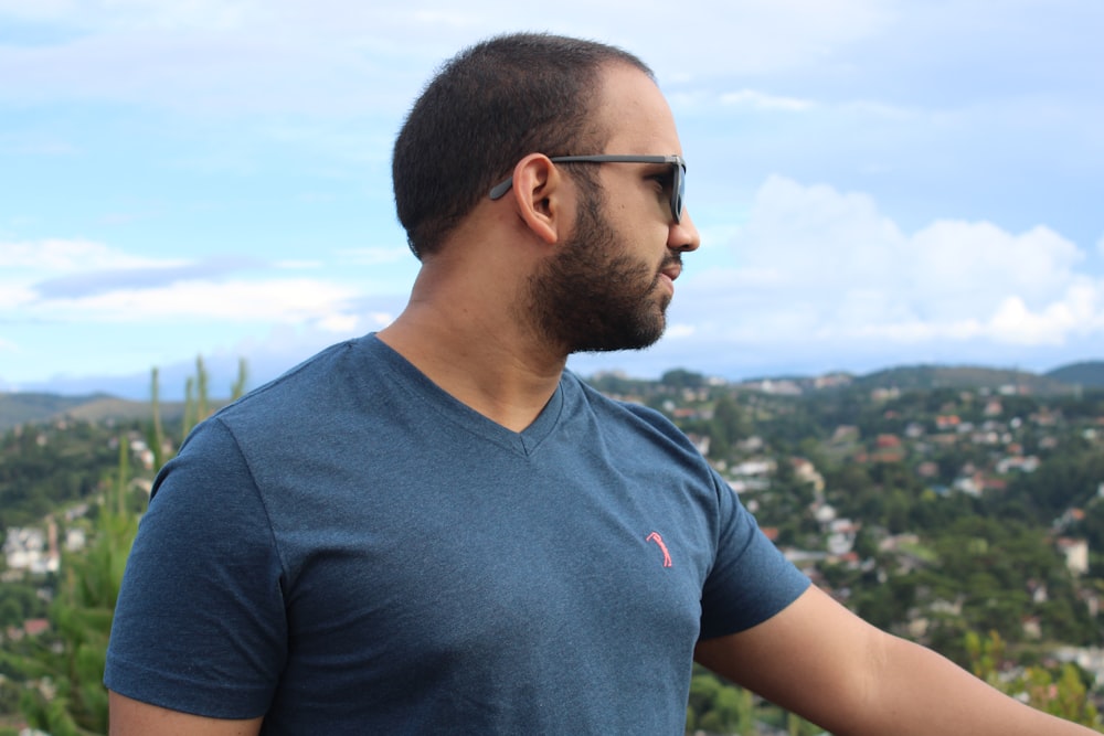 a man in a blue shirt is holding a cell phone