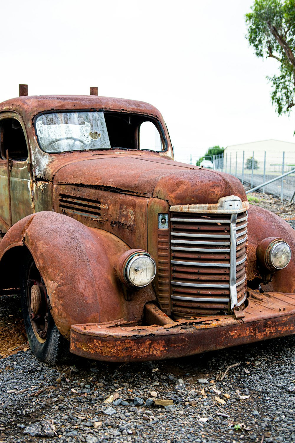 砂利原の上に座っている古い錆びたトラック