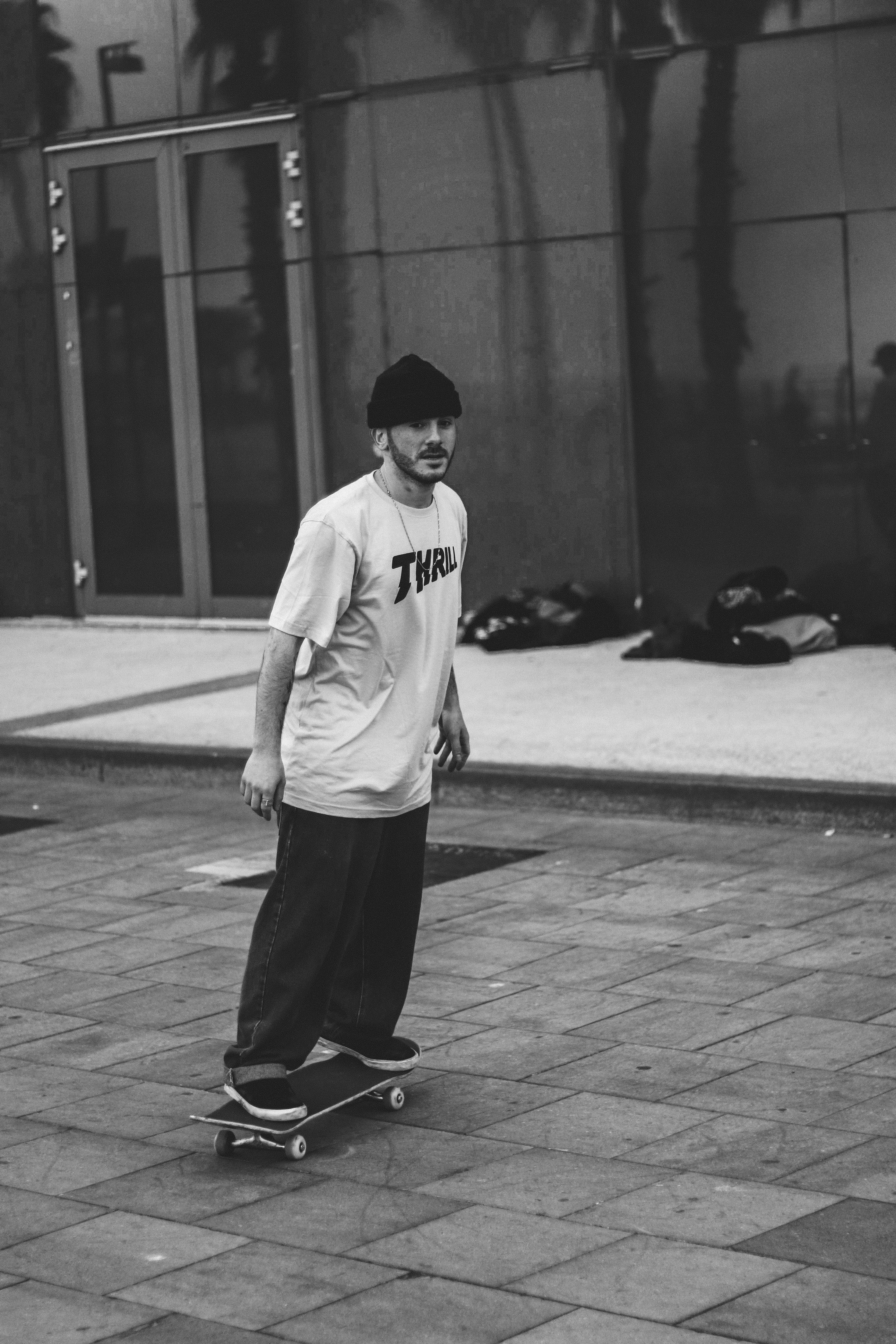 a man riding a skateboard down a sidewalk