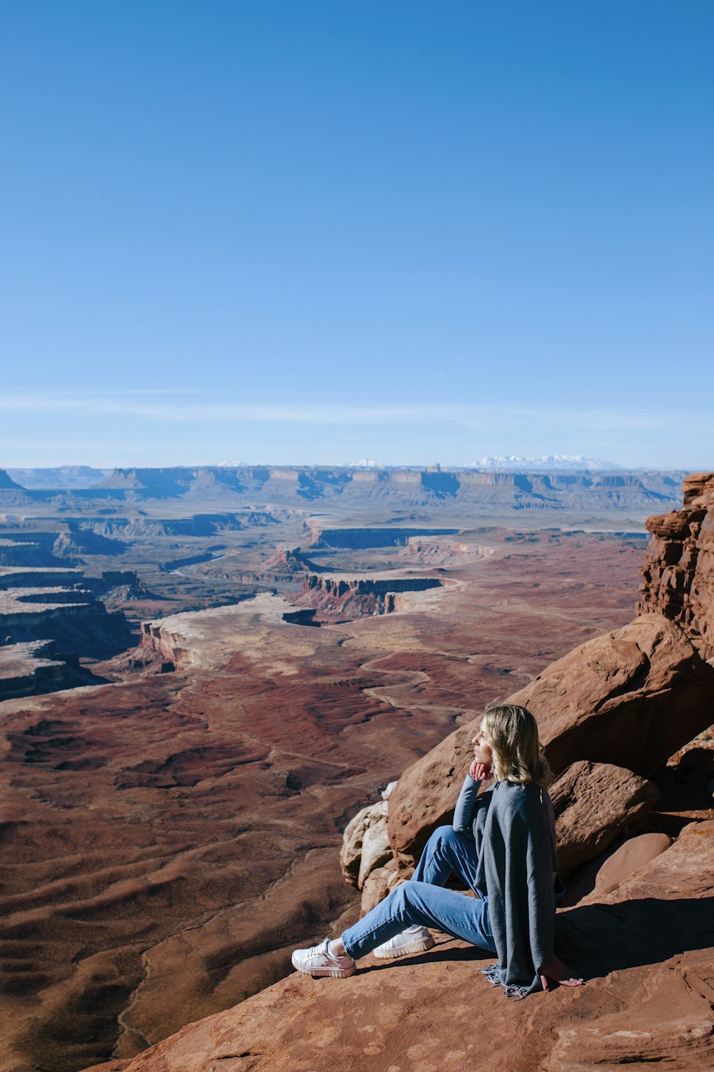 a woman sitting on top of a large rock