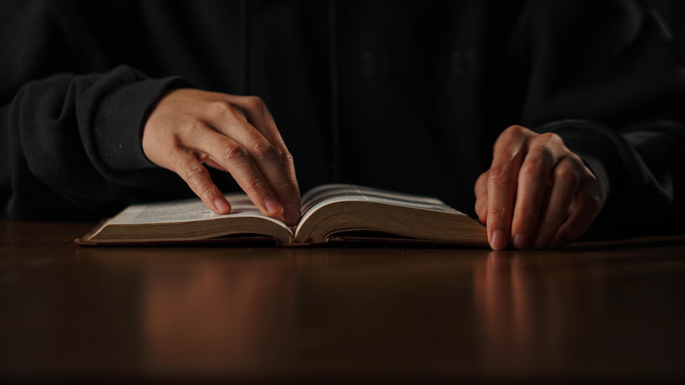 a person is reading a book on a table