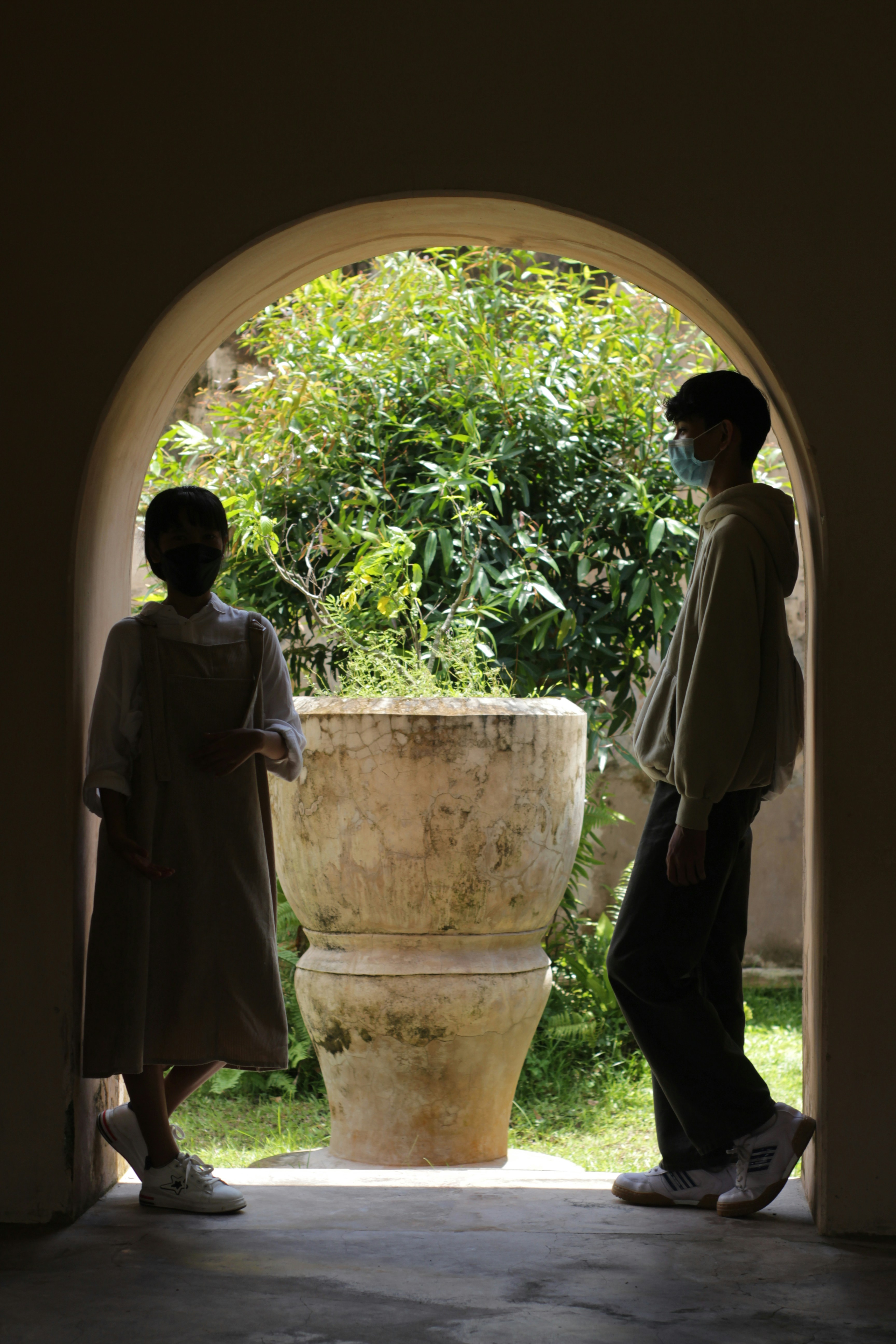 Un couple de personnes debout devant un vase