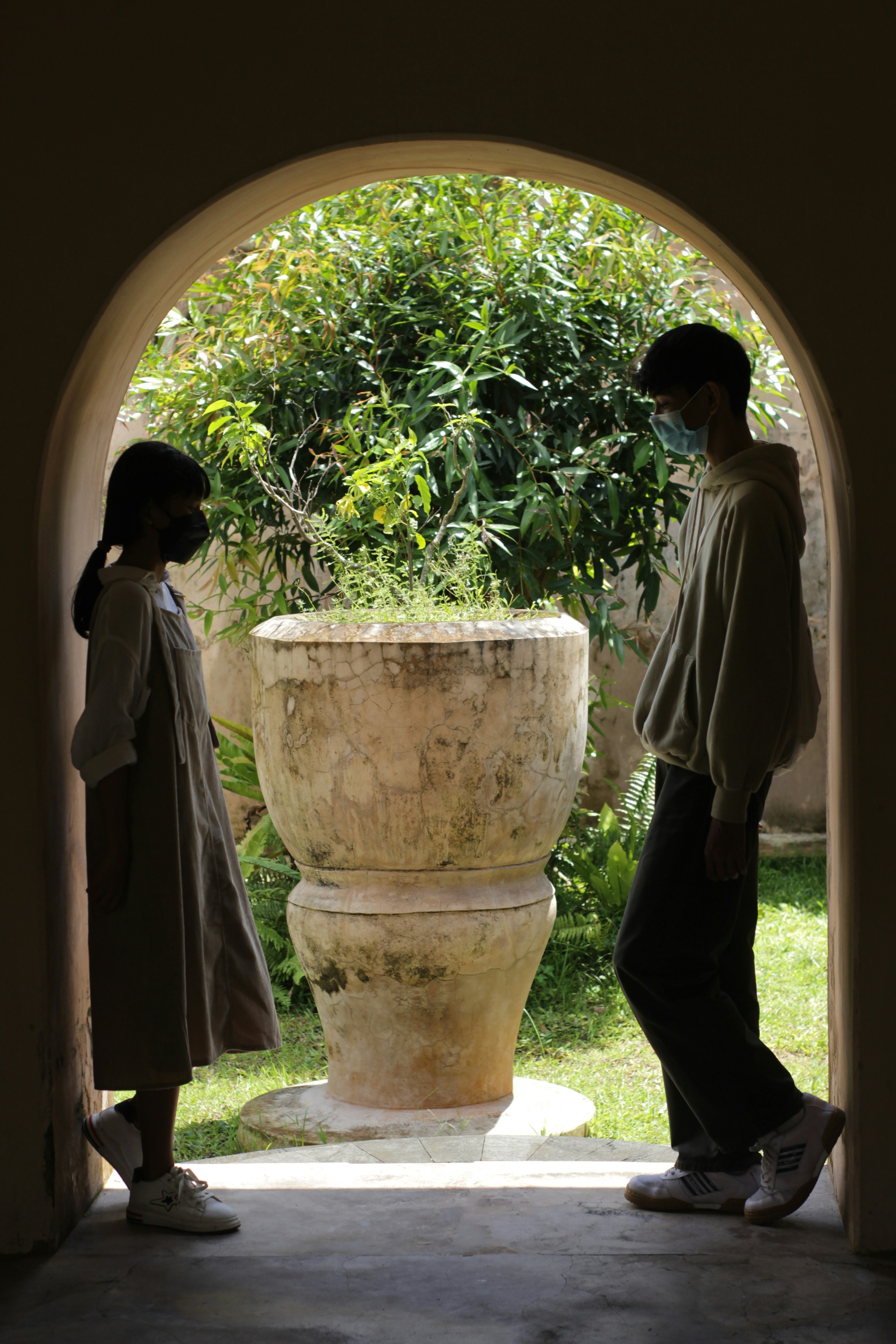 Un couple de personnes debout devant un vase