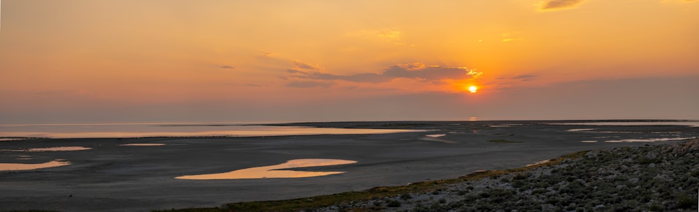 the sun is setting over a large body of water