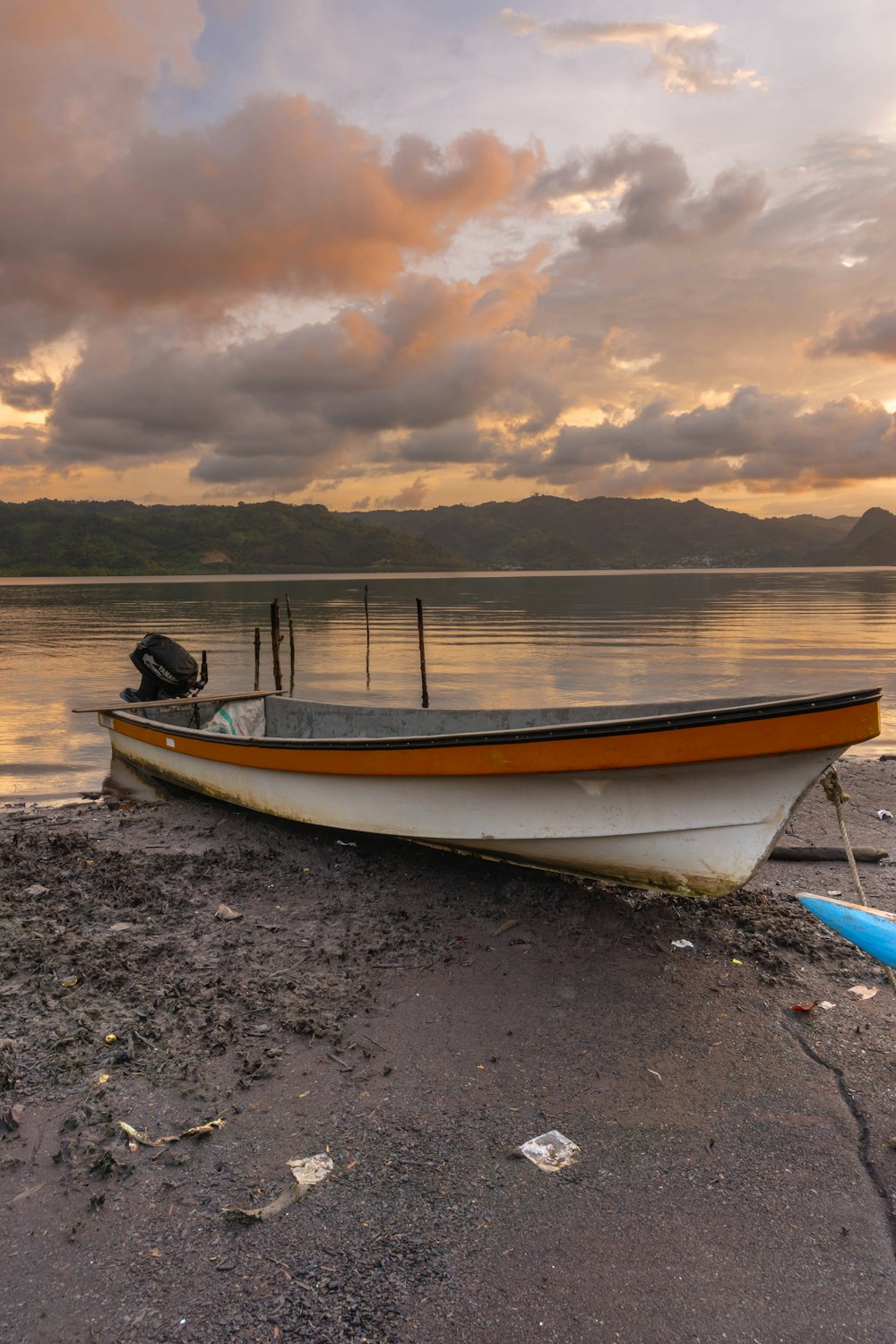 a boat sitting on the shore of a lake